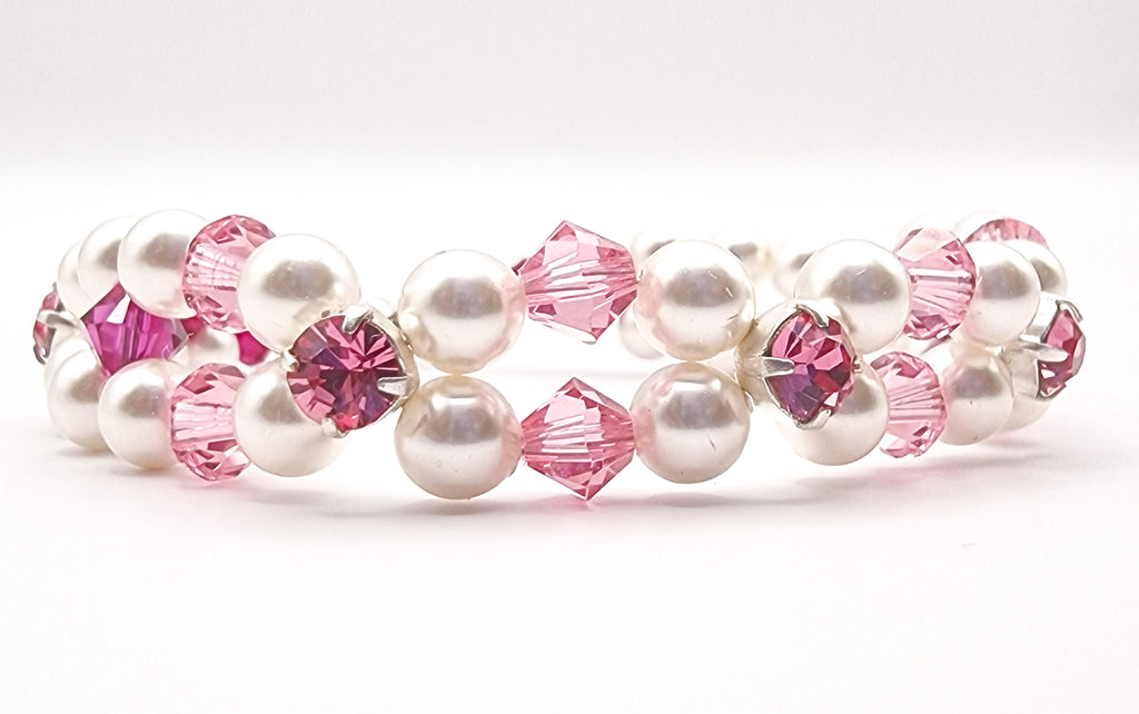 Experience timeless elegance with a handwoven bracelet featuring luminous golden Austrian pearls and a striking red crystal accent. A refined, chic accessory for any occasion.