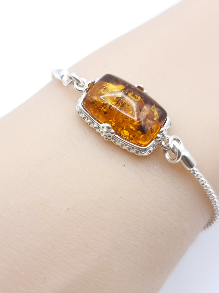 Elegant lariat-style bracelet crafted from sterling silver, featuring gorgeous natural Baltic amber in a rich cognac hue. A sophisticated blend of timeless charm and modern design.