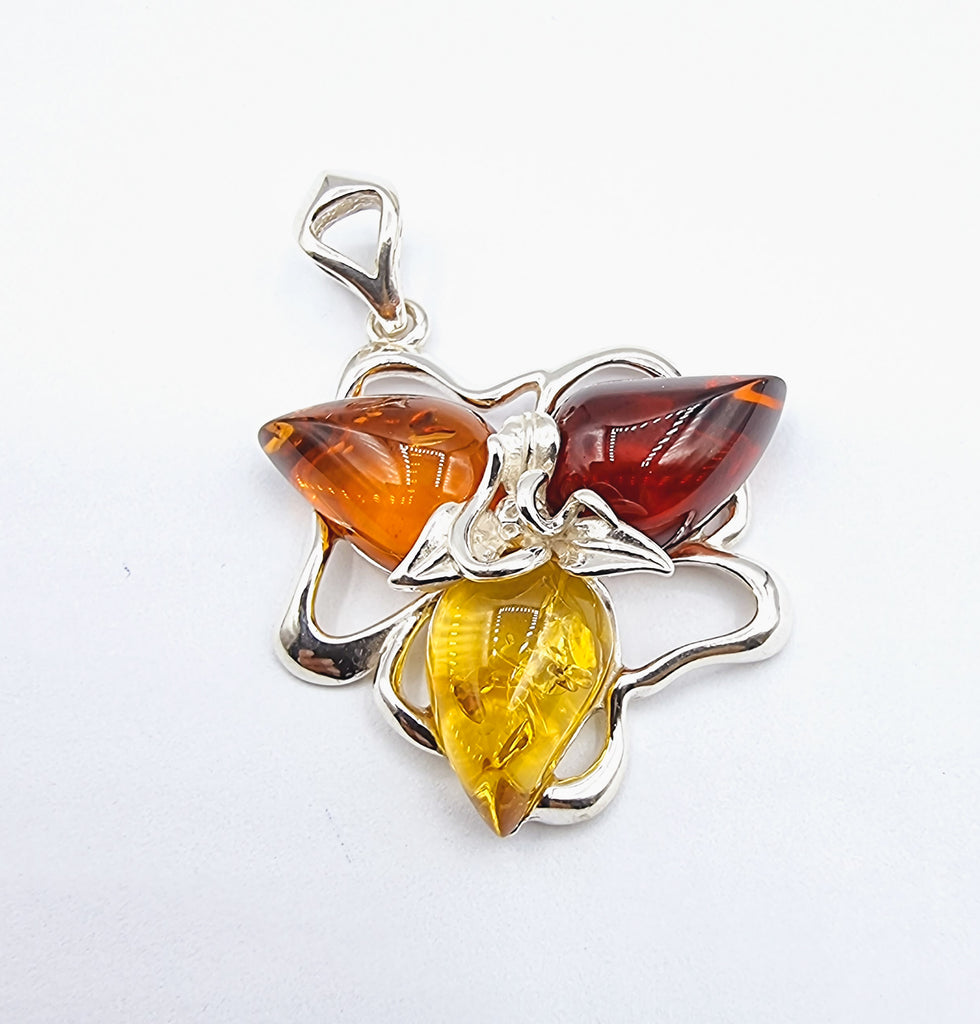 Beautiful pendant representing a flower set on sterling silver with 3 tone natural Baltic Ambers in light yellow, cognac and cherry red tones.