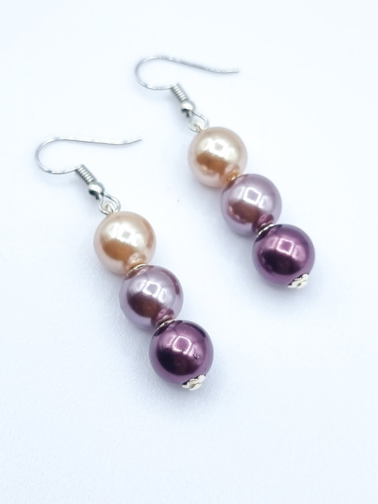 A pair of dangling imitation lustrous pearl earrings, designed and handmade in lovely hues of pink. 