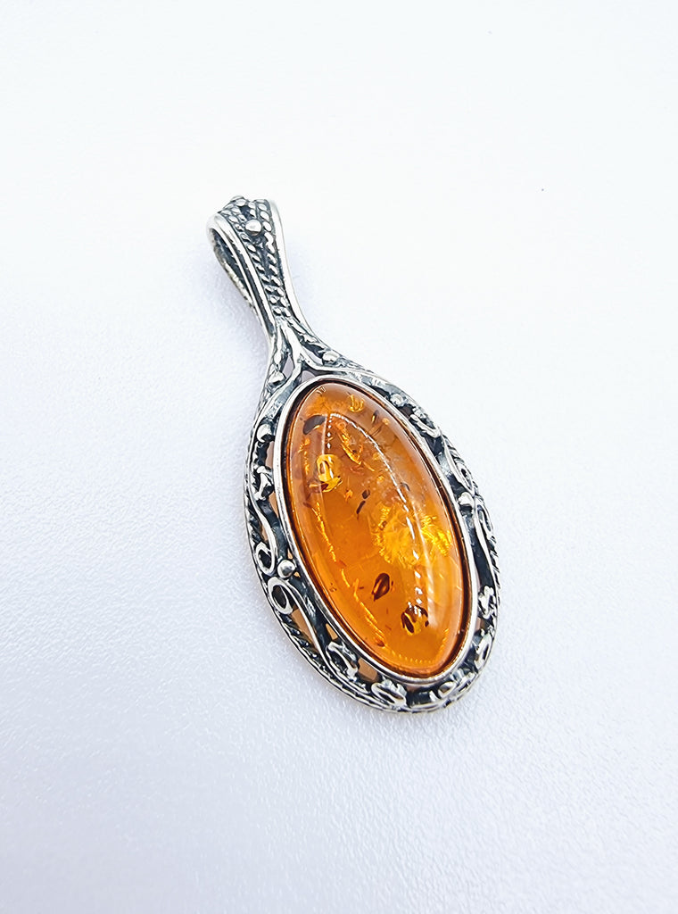 Classy sophisticated natural Baltic Amber pendant in Cognac tone, set on decorative swirl Sterling Silver bezel