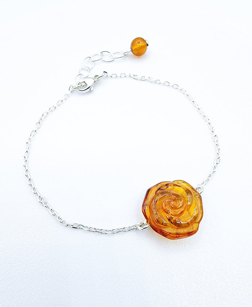 An elegant minimalist bracelet crafted with a carved rose from natural yellow Baltic Amber, and set on a Sterling Silver chain. An elegant bracelet, perfect for any occasion.