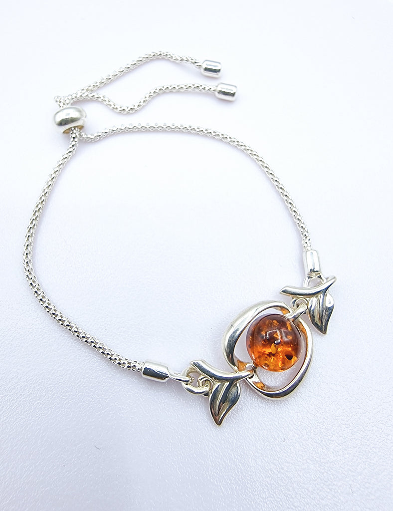 An elegant adjustable bracelet crafted on Sterling Silver, featuring a tiny Apple with a cognac natural Baltic Amber. 