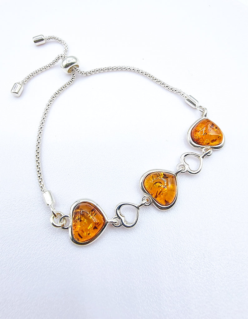 An elegant adjustable bracelet crafted with luxurious heart shaped cognac natural Baltic Amber on Sterling Silver. Its adjustable closure allows for perfect and comfortable fit. 