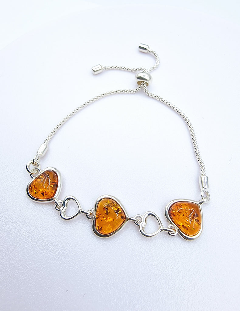 An elegant adjustable bracelet crafted with luxurious heart shaped cognac natural Baltic Amber on Sterling Silver. Its adjustable closure allows for perfect and comfortable fit. 