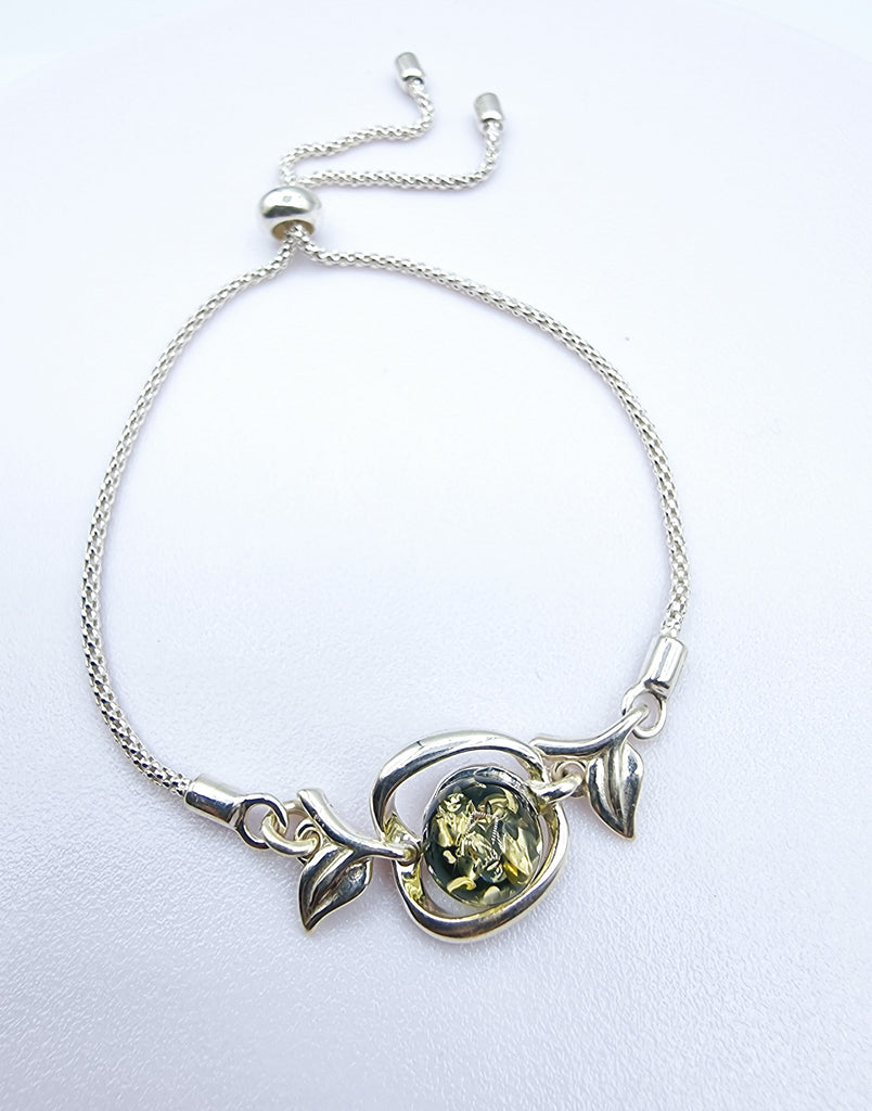 An elegant adjustable bracelet crafted on Sterling Silver, featuring a tiny Apple with a green natural Baltic Amber.