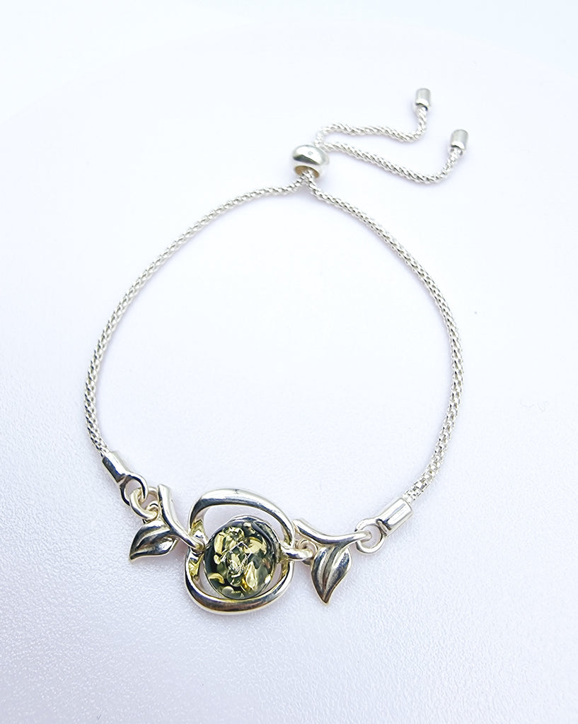 An elegant adjustable bracelet crafted on Sterling Silver, featuring a tiny Apple with a green natural Baltic Amber.