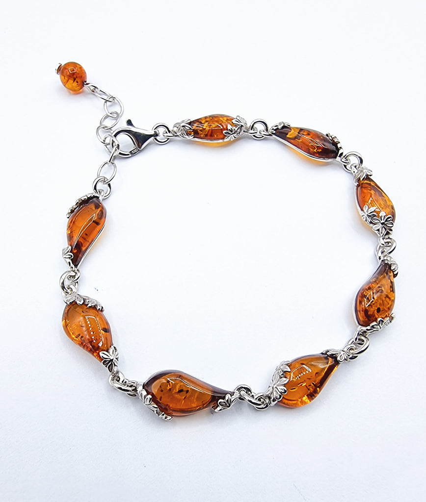 An elegant link bracelet crafted with eight paisley shaped natural cognac Baltic Amber, on Sterling Silver, creating a luxurious and eye catching look. 