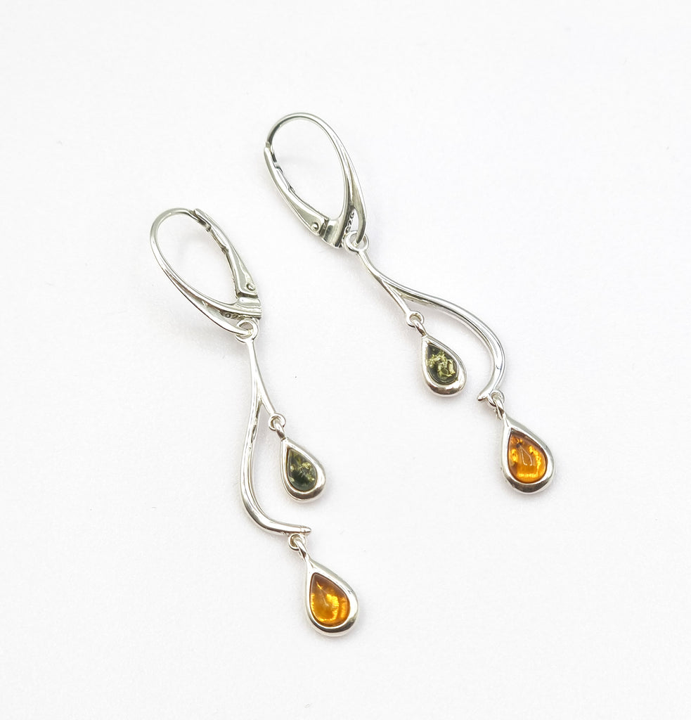 A pair of truly elegant earrings, crafted on Sterling Silver in a stunning curve and swirl pattern. Accentuated with 2 tone gorgeous teardrop Baltic Amber drops, it adds a touch of sophistication. Set on lever back earring wire. Origin Poland