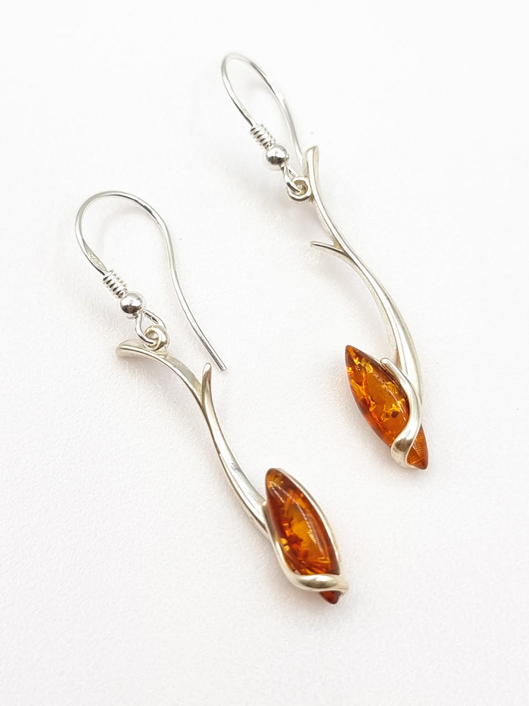 A statement making elegant dangling earrings crafted with 925 Sterling Silver in a stunning vine swirl, with a shimmering marquis shaped cognac natural Baltic Amber. Sure to add a luxurious look. Origin Poland