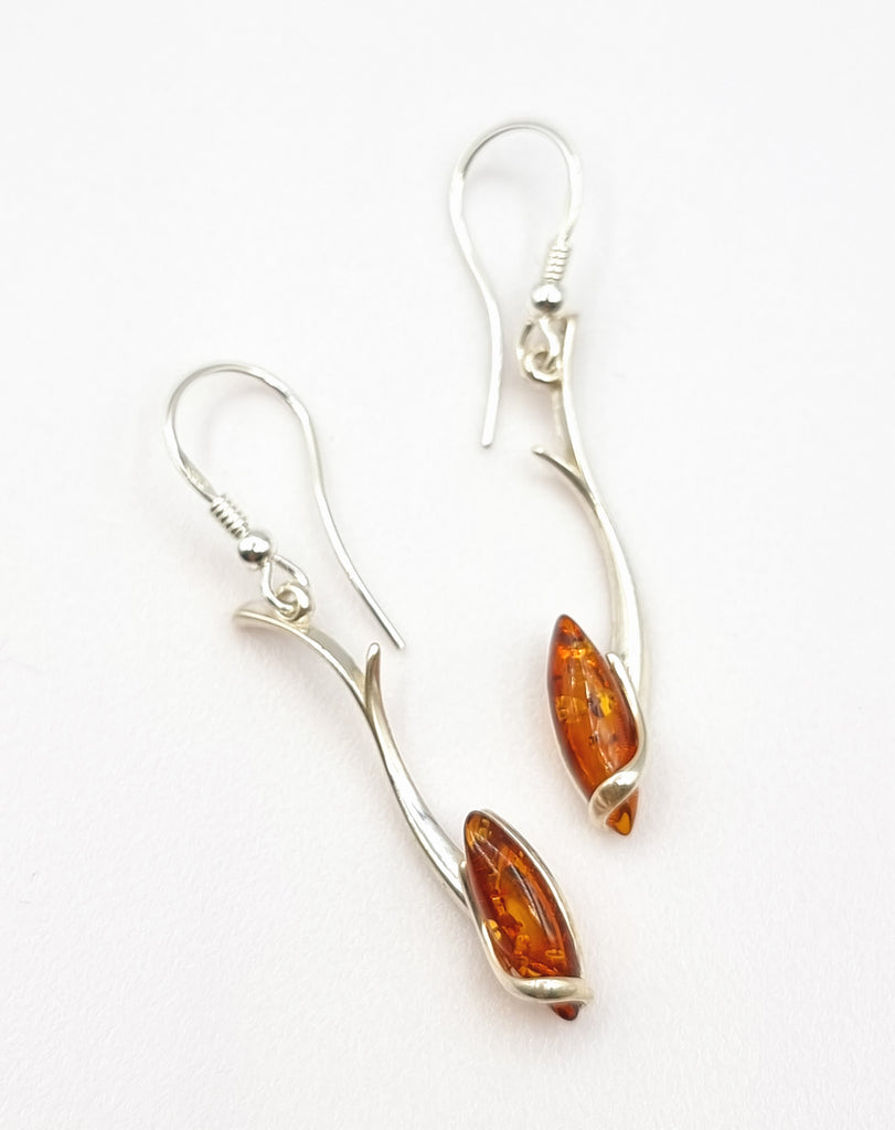 A statement making elegant dangling earrings crafted with 925 Sterling Silver in a stunning vine swirl, with a shimmering marquis shaped cognac natural Baltic Amber. Sure to add a luxurious look. Origin Poland