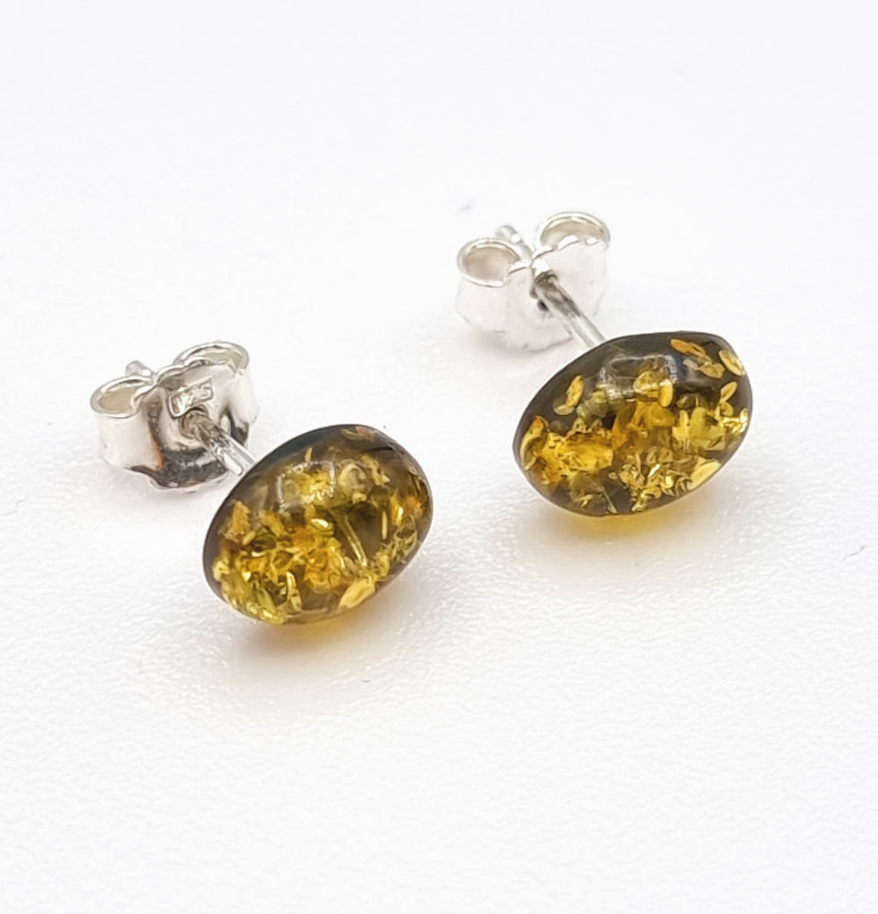 A pair of beautiful green natural Baltic Amber stud earrings, set on 925 Sterling Silver posts. The stunning Amber cabochon reflects gorgeous inclusions that shimmer like gold, adding a luxurious touch. Origin Poland