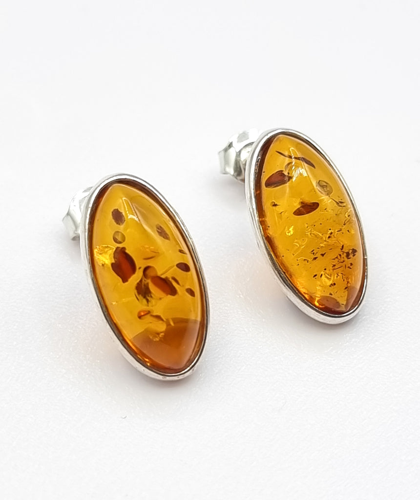 A pair of oval shaped exquisite cognac natural Baltic Amber stud earrings, crafted on simple Sterling Silver bezel settings, is sure to make it a sophisticated addition to any jewelry collection. The deep cognac hue of this gorgeous Amber creates a unique and luxurious appeal. Origin Poland