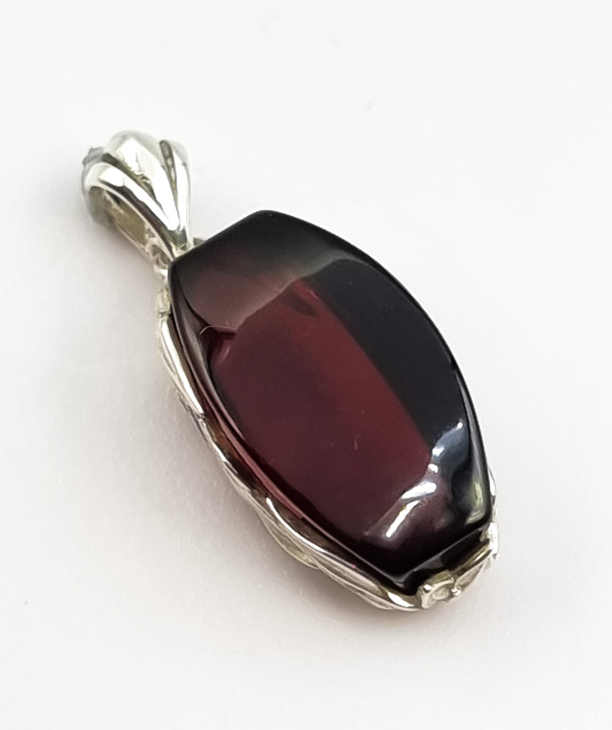 A gorgeous rectangular natural Baltic Amber pendant, crafted with a stunning deep cherry red hue Amber, encased in a beautiful 925 Sterling Silver vine bezel. Truly an elegant, luxurious, sophisticated piece of jewelry. Origin Poland.