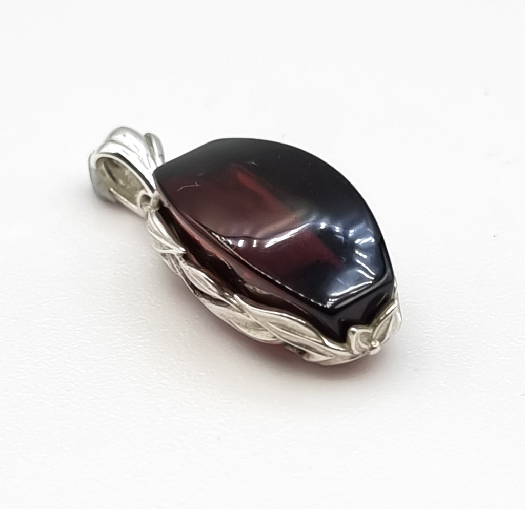 A gorgeous rectangular natural Baltic Amber pendant, crafted with a stunning deep cherry red hue Amber, encased in a beautiful 925 Sterling Silver vine bezel. Truly an elegant, luxurious, sophisticated piece of jewelry. Origin Poland.