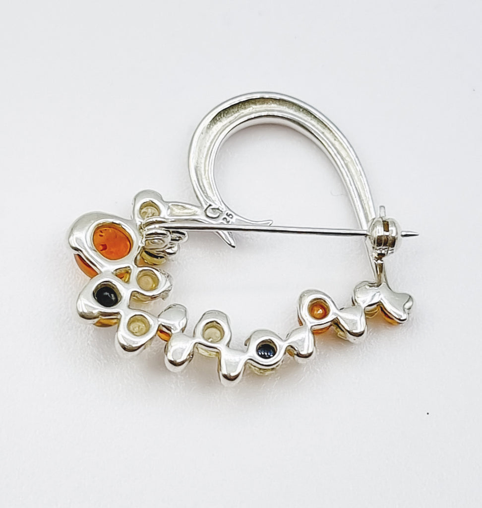 A gorgeous contemporary heart shaped brooch crafted with 3 shades of natural Baltic Amber, on 925 Sterling Silver. In shades of cognac, green and light yellow, the Ambers shimmer with grace. It is sure to add a sophisticated, elegant look to any ensemble. Origin Poland