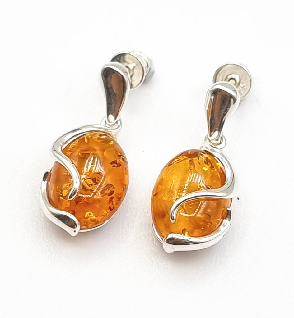 A pair of exquisite Baltic Amber earrings, crafted with 925 Sterling Silver, and natural cognac Amber stone with gorgeous inclusions. With a beautiful swirl pattern and its dangling drop style, it will add a classy and sophisticated touch to any look. Origin Poland