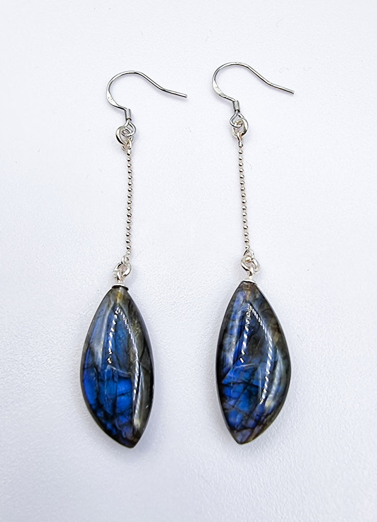 A pair of gorgeous dangling earrings crafted with vibrant blue iridescent natural Labradorite stones, sourced from Madagascar. Set on sterling silver  earring hook and a chain, these earrings are truly a one-of-a-kind piece of nature's artistry.