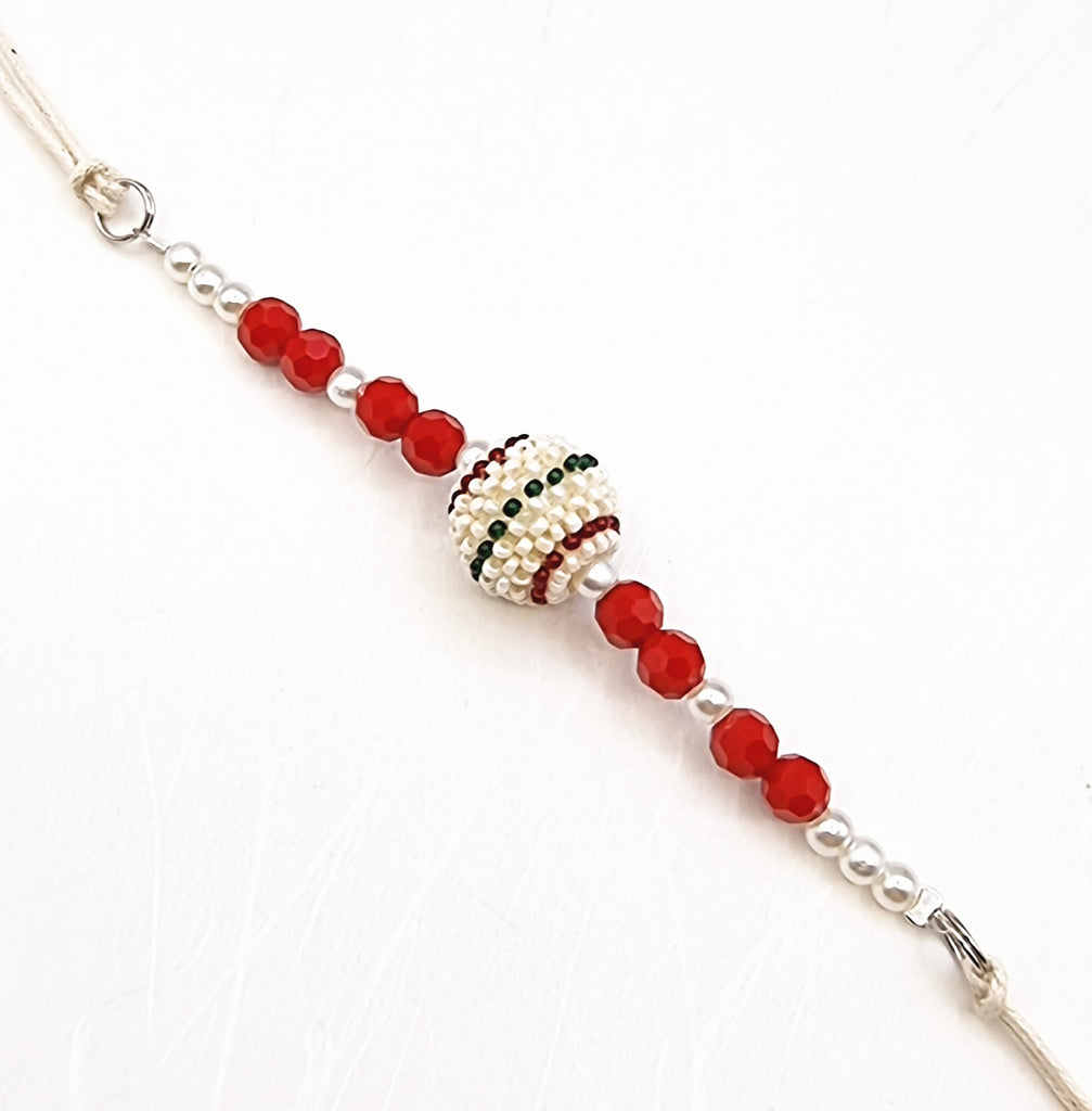 A handmade Rakhi delicately designed and crafted with imitation red crystals and imitation white lustrous pearl, with a beautiful beaded pearl accent. Truly unique and one-of-a-kind!