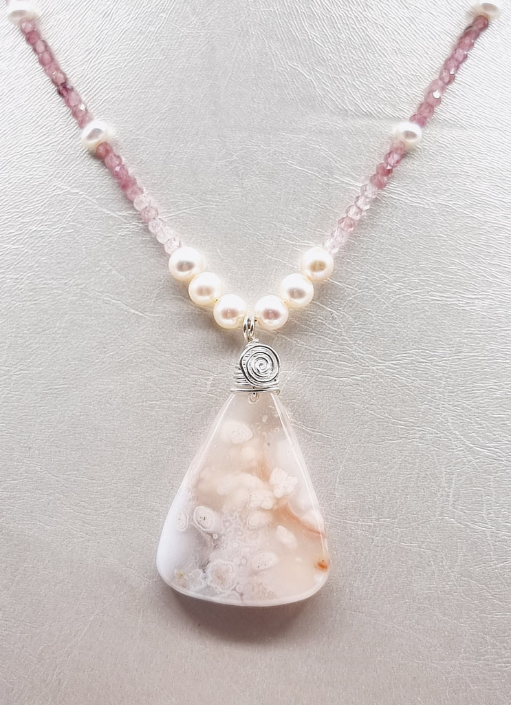 Elevate your style with our handmade Blush of  Pink necklace. Designed with Natural Pink Tourmaline gemstones, a gorgeous Sakura Agate accent, and beautiful shimmering lustrous Freshwater Pearls, this necklace creates a timeless, elegant look. Perfect for any occasion, this necklace is a statement of grace and femininity.