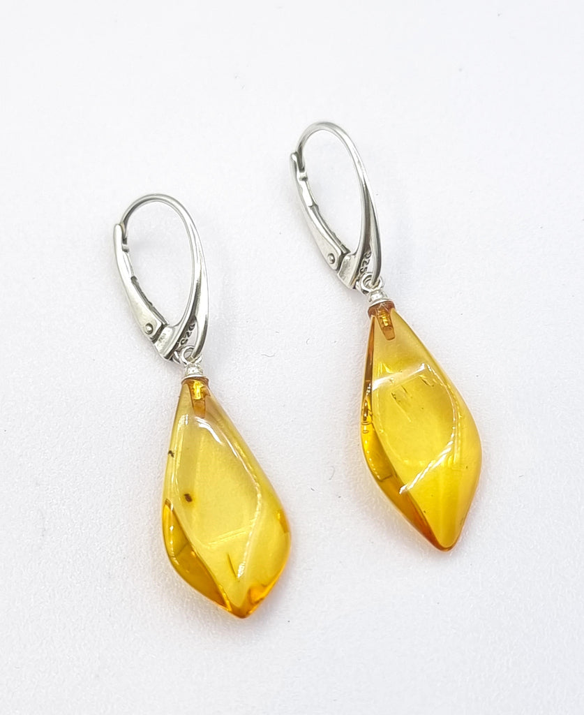 Elevate your style with sophistication in these faceted Citrine natural Baltic amber drop earrings. The exquisite tone of Citrine and Baltic amber adds elegance to any look. With a refined drop design and exquisite carving, these earrings are both simple and graceful. Origin: Poland.