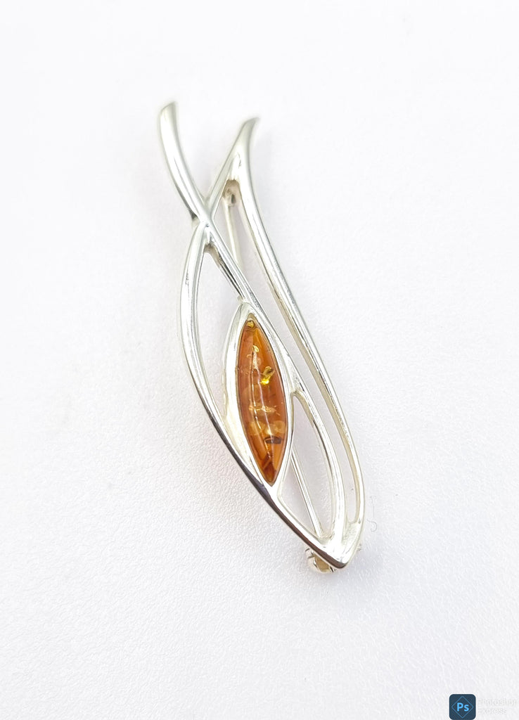 Discover sophistication and luxury in this exquisite paisley-shaped brooch, crafted with natural Baltic amber in a gorgeous cognac hue. Made with sterling silver and originating from Poland, this accessory boasts a tasteful swirl design, elevating any outfit with exclusive charm.