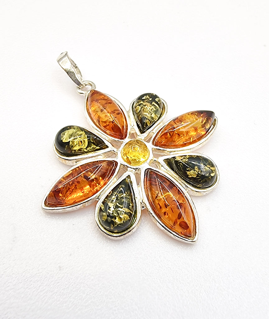 A stunning natural Baltic amber pendant featuring three tones of amber, crafted in sterling silver. Originating from Poland, this elegant statement piece is truly beautiful and sophisticated.