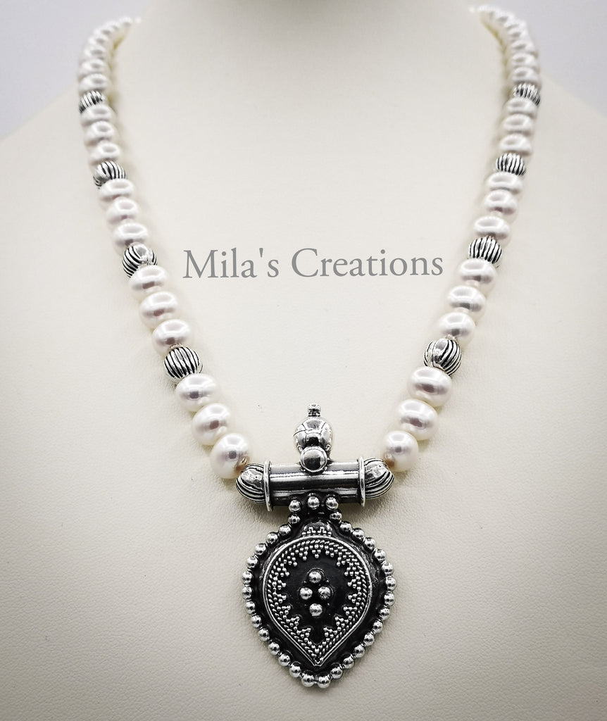 A beautiful one of a kind necklace handmade with cultured Freshwater Pearls and Sterling Silver Pendant, spaced with tiny little Sterling Silver Beads. It has been handmade with professional knotting technique adding a splendid finish to the piece