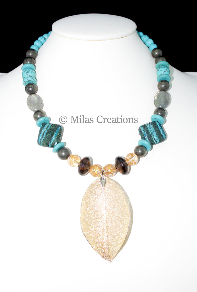 A handmade Choker Length Necklace designed with a combination of Rainbow Jasper, Smoky Quartz, Labradorite, Pyrite and Howlite adds a beautiful medley to the gold leaf accent. 