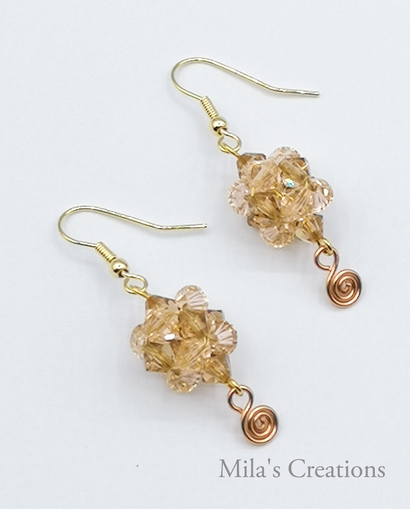 A handwoven pair of earrings designed with beige and peach Swarovski Crystals. A perfect gift of love!